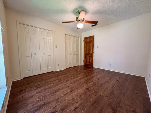 a view of an empty room with a chandelier fan