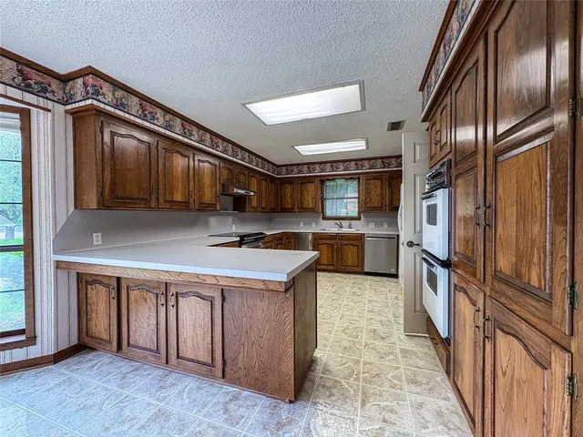 a kitchen with stainless steel appliances granite countertop a refrigerator a stove and a sink