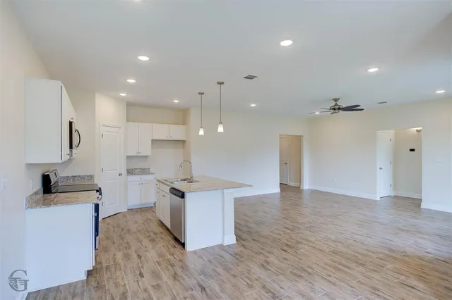 a view of kitchen with sink and refrigerator