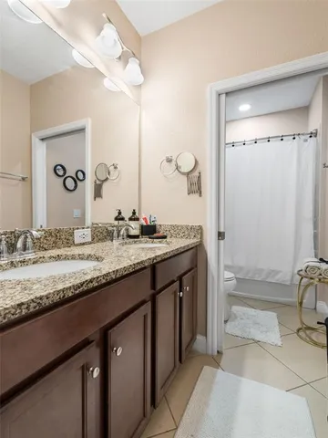a bathroom with a granite countertop sink a mirror and a shower
