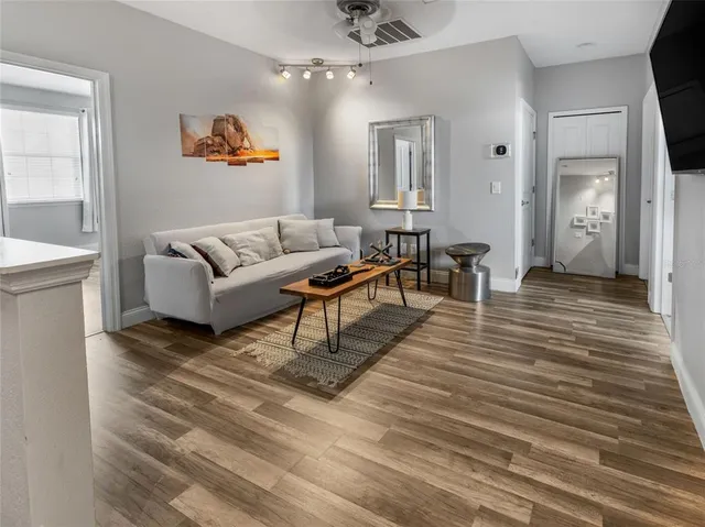 a living room with furniture and a wooden floor