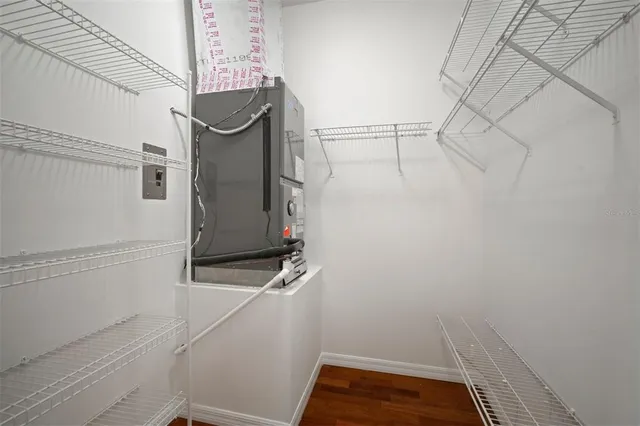 an empty room with wooden floor closet and windows