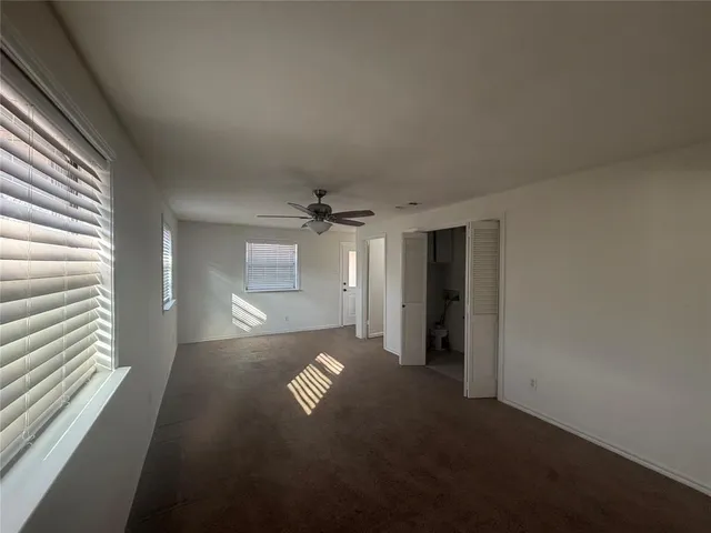 an empty room with windows and cabinet