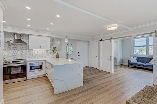 a large kitchen with stainless steel appliances granite countertop a stove and a wooden floors