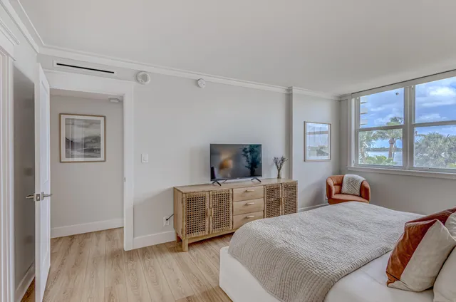 a bedroom with a bed and a flat tv screen on the dresser