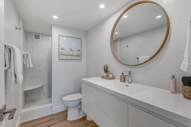 a bathroom with a toilet a sink and mirror