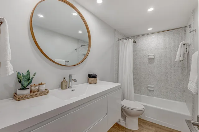 a bathroom with a sink a toilet and a mirror
