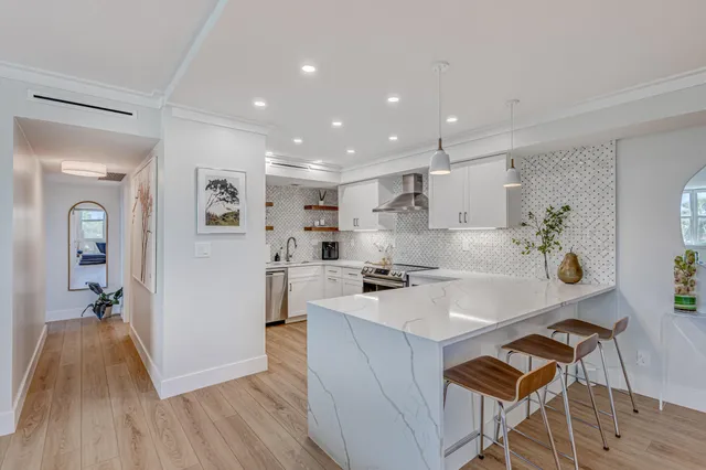 a kitchen with granite countertop a stove a sink and a refrigerator