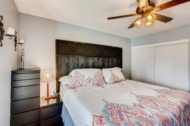 a bedroom with a bed and a chandelier fan