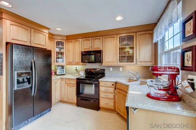 a kitchen with stainless steel appliances granite countertop a refrigerator stove and sink