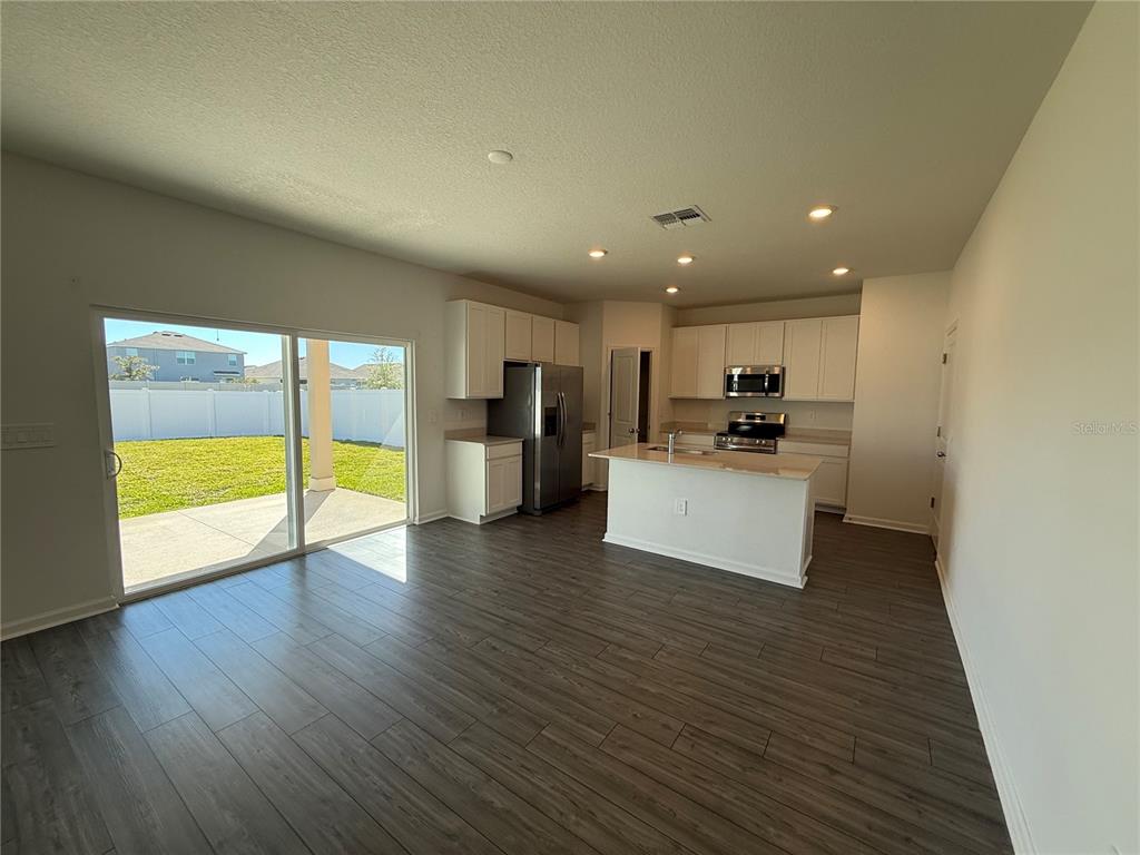 4701 Southwest 83rd Loop Ocala, FL 34476 - Photo 4 of 17 a view of kitchen with refrigerator and wooden floor