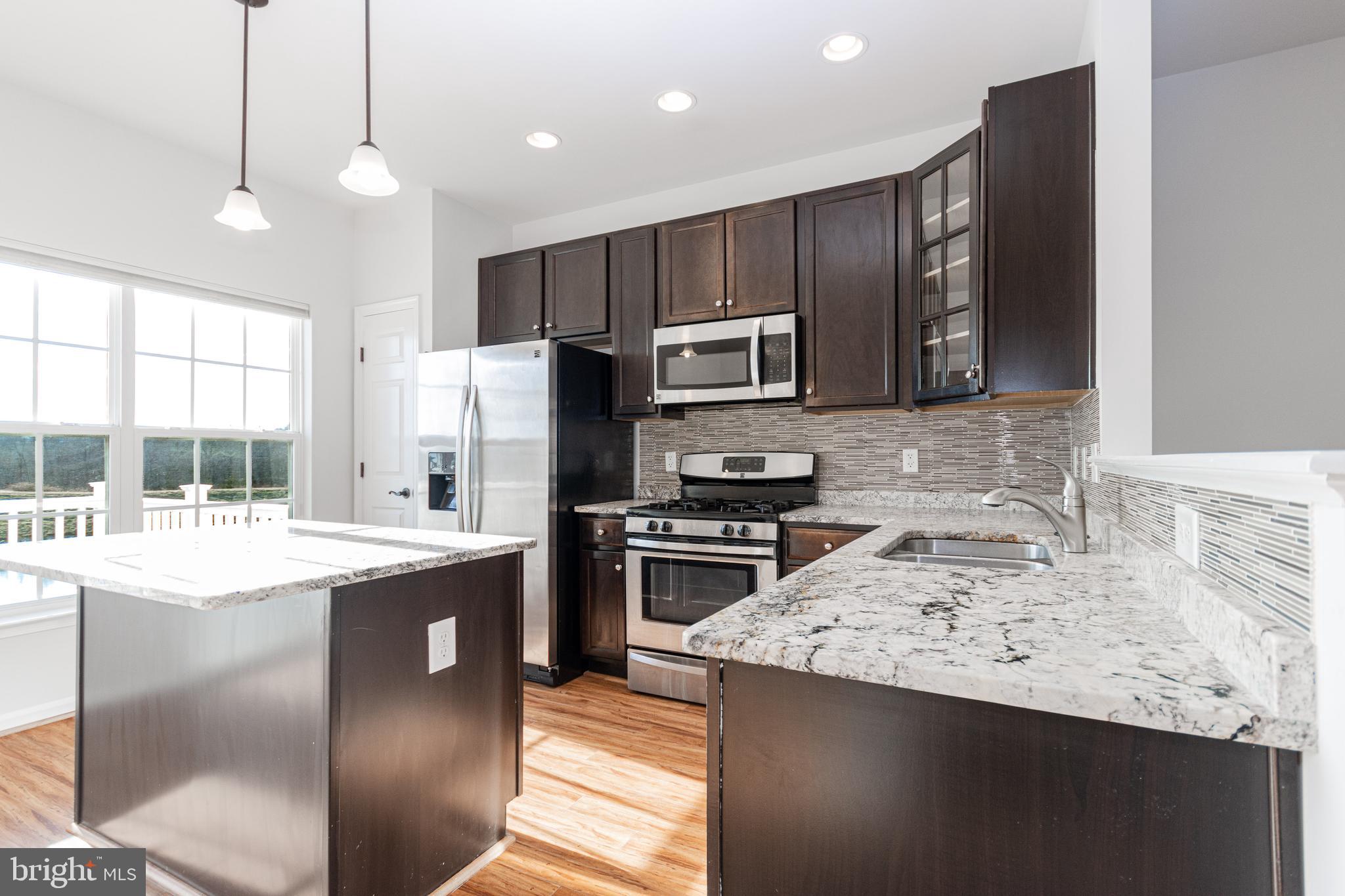 4905 Wensel Road Fredericksburg, VA 22408 - Photo 5 of 23 a kitchen with kitchen island granite countertop a sink stove and refrigerator