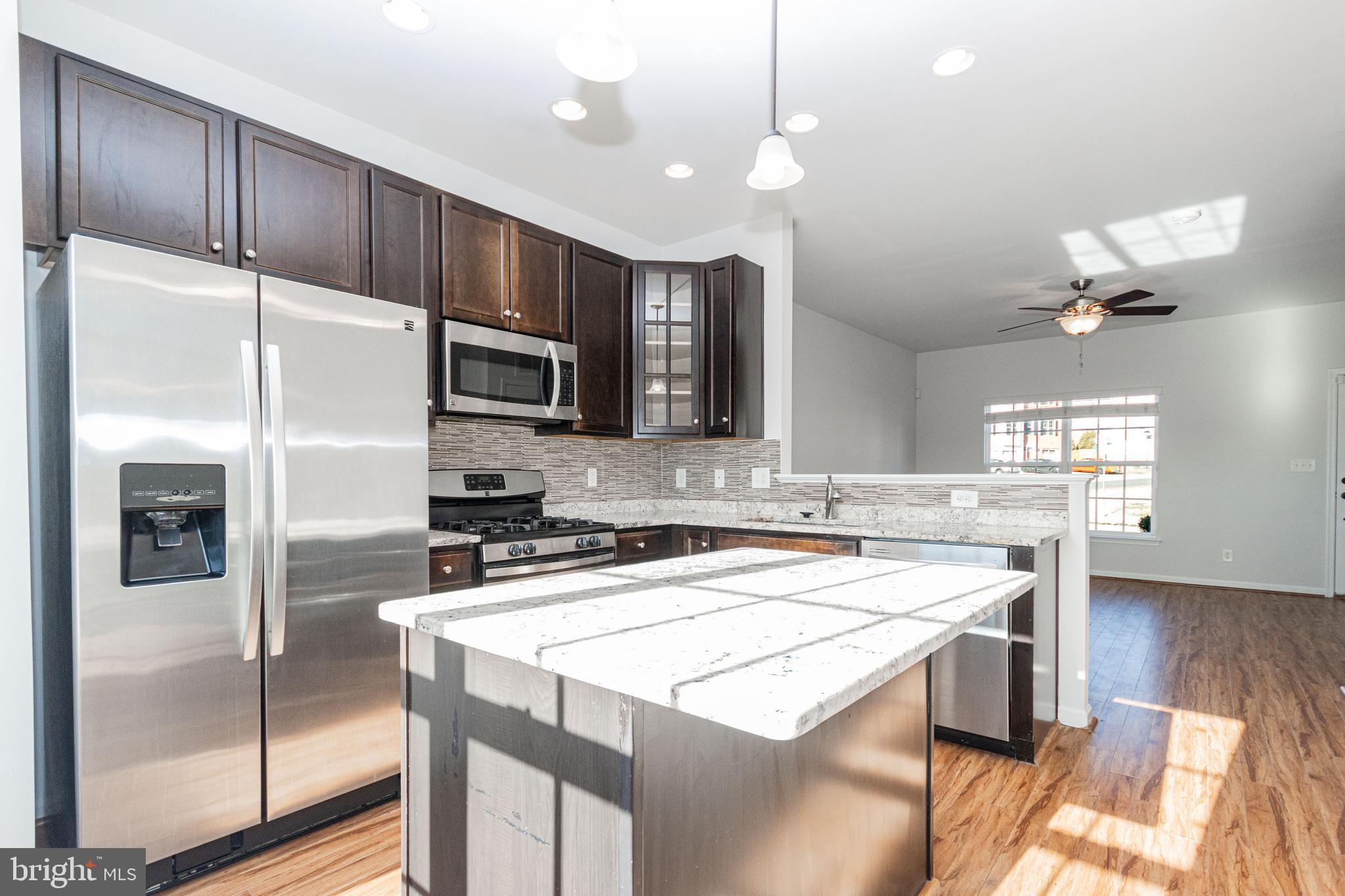 4905 Wensel Road Fredericksburg, VA 22408 - Photo 6 of 23 a kitchen with kitchen island a counter space a sink appliances and cabinets