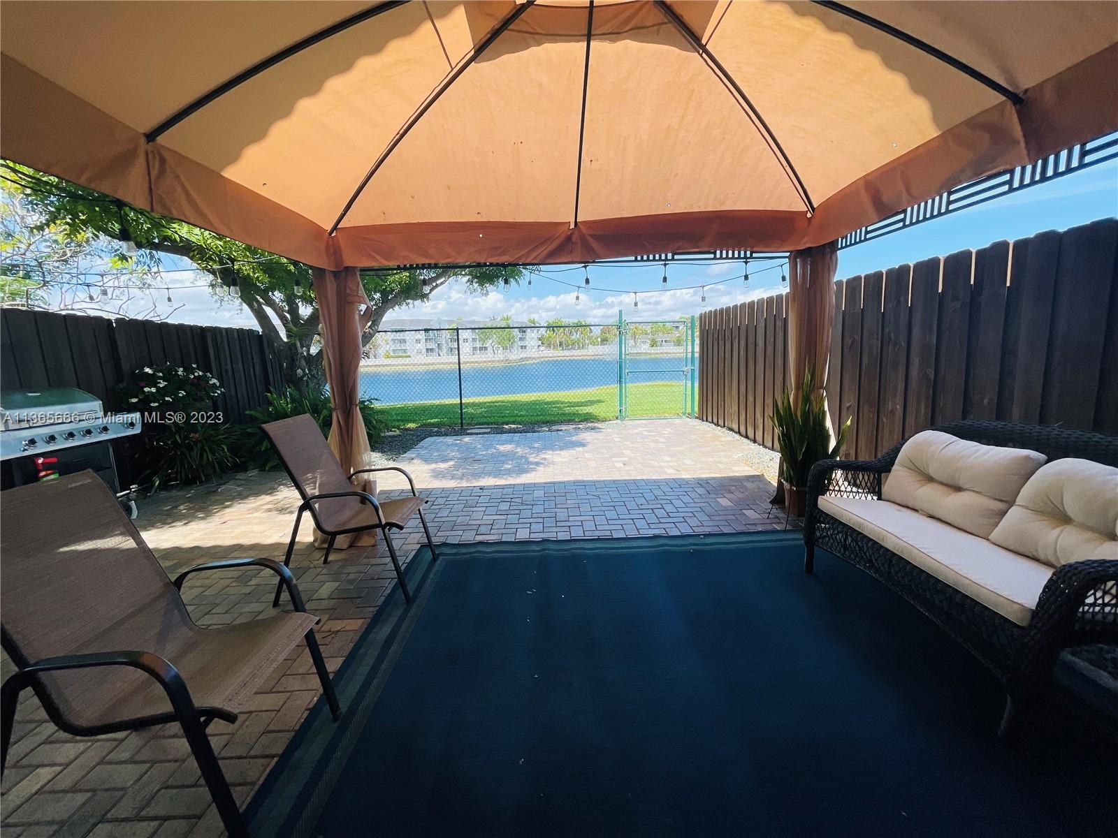 a view of a patio with a table and chairs under an umbrella