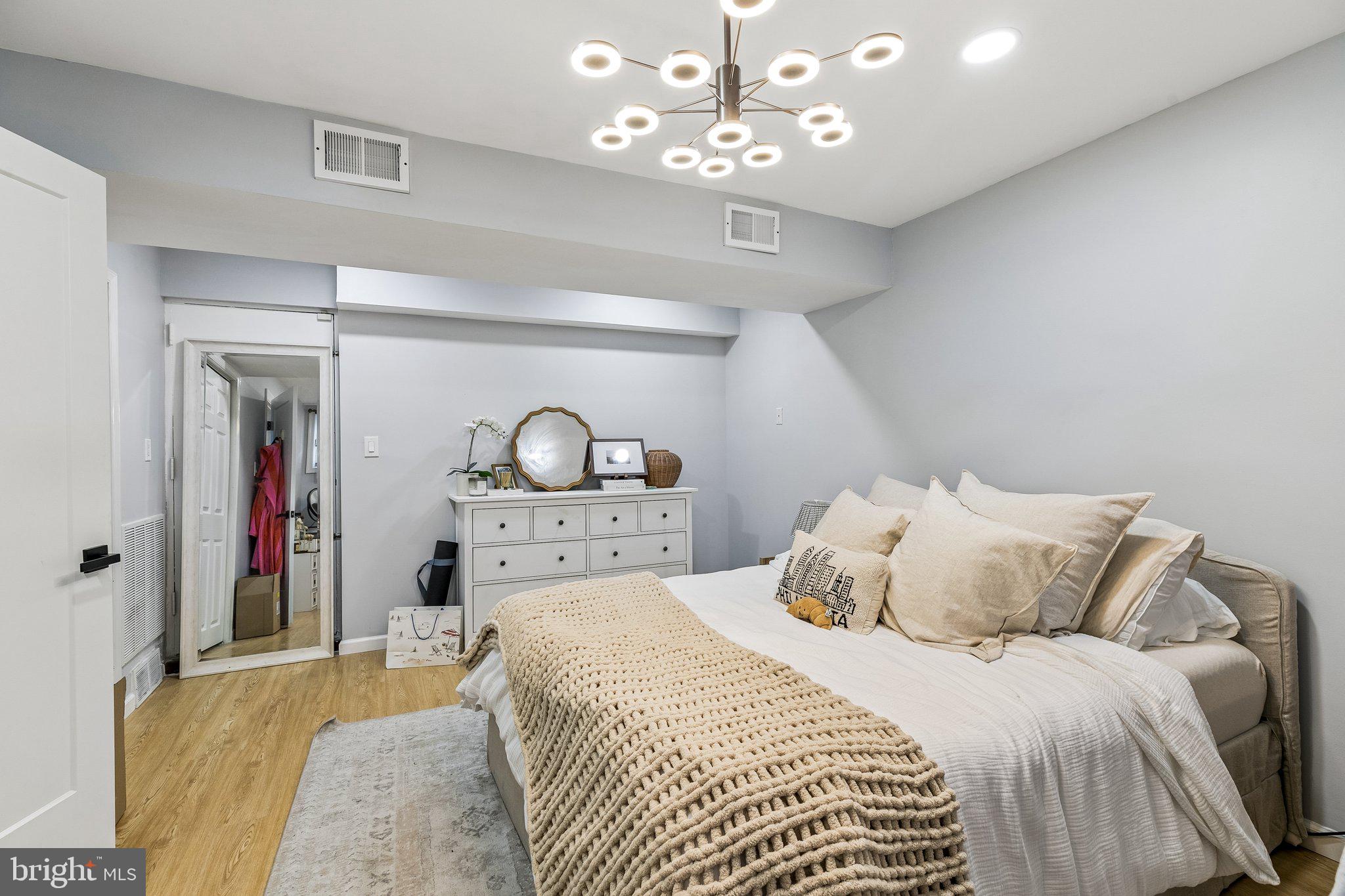 1130 Lombard Street Philadelphia, PA 19147 - Photo 33 of 45 a bedroom with a bed and a chandelier
