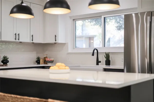 a kitchen with stainless steel appliances a sink a stove and a large window