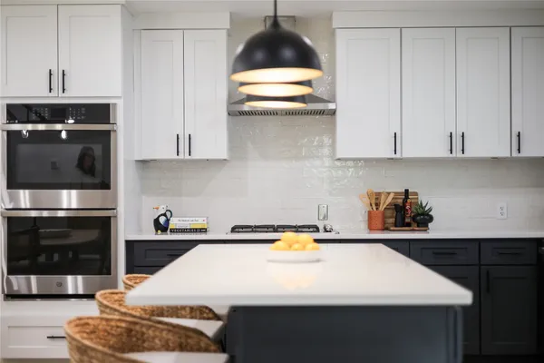 a kitchen with kitchen island a sink dishwasher and a stove
