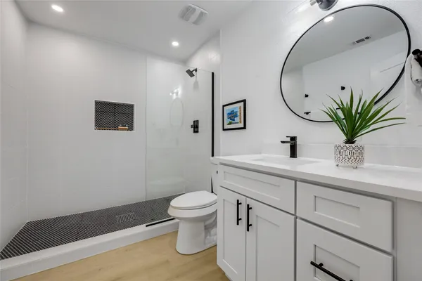 a bathroom with a sink a toilet and shower