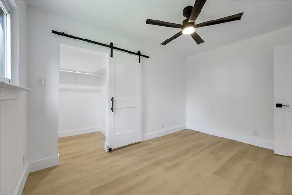 a view of a big room with wooden floor closet and windows