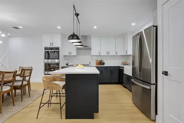 a kitchen with kitchen island a counter top space appliances and cabinets