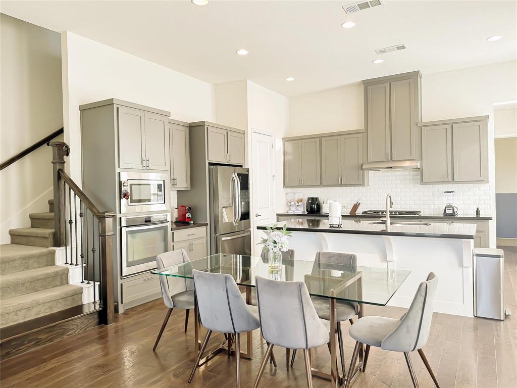 7605 Kickapoo Drive McKinney, TX 75070 - Photo 3 of 18 a kitchen with stainless steel appliances granite countertop a table chairs stove microwave and cabinets