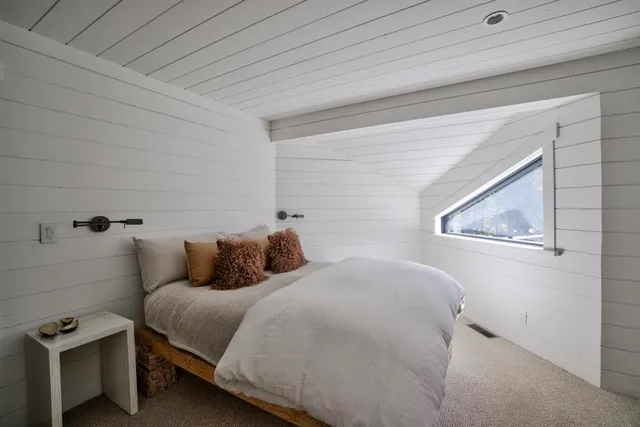 a bed sitting in a bedroom next to a window