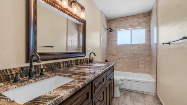 a bathroom with a granite countertop bathtub sink and mirror