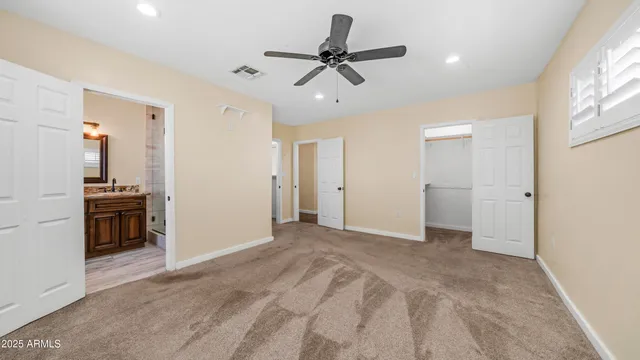 a view of a livingroom with a ceiling fan & entryway