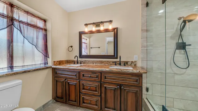 a bathroom with a granite countertop sink a toilet and a mirror