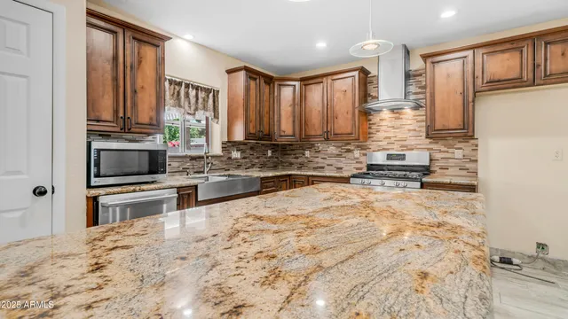a kitchen with stainless steel appliances a stove a sink and a refrigerator