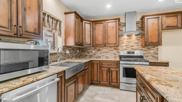 a kitchen with stainless steel appliances granite countertop a stove a sink and a microwave