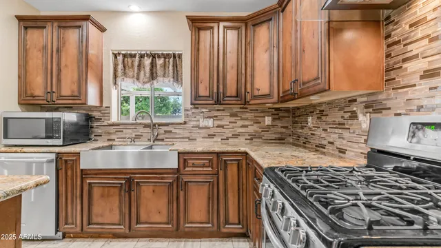a kitchen with granite countertop a stove sink and cabinets