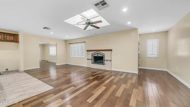 a view of empty room with wooden floor and fireplace