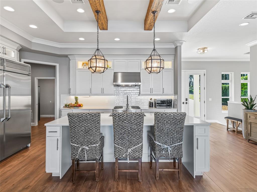 12943 Southeast Sunset Harbor Road Weirsdale, FL 32195 - Photo 18 of 87 a dining room with furniture a chandelier and wooden floor