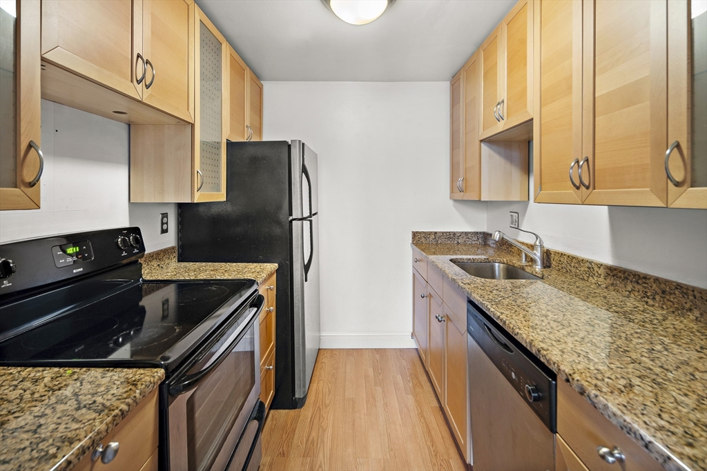 201 Thorndike Street, Unit 205 Lowell, MA 01852 - Photo 5 of 13 a kitchen with granite countertop a sink stove and refrigerator