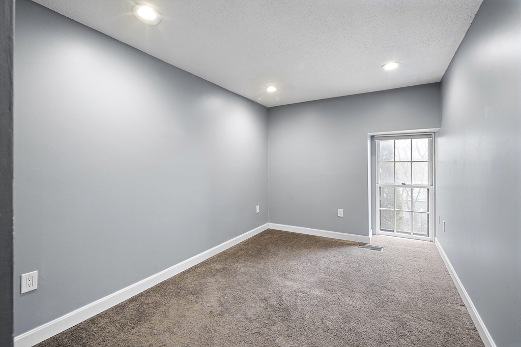 201 Thorndike Street, Unit 205 Lowell, MA 01852 - Photo 8 of 13 an empty room with windows