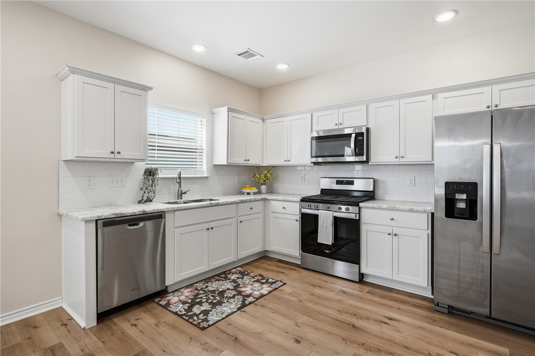 124 Lavaca Rockport, TX 78382 - Photo 11 of 39 a kitchen with granite countertop a refrigerator stove top oven and sink