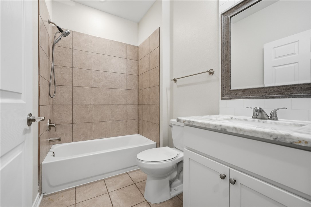 124 Lavaca Rockport, TX 78382 - Photo 21 of 39 a bathroom with a granite countertop toilet a sink and bathtub
