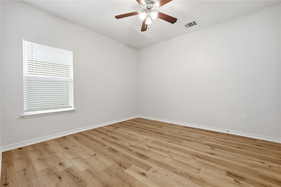124 Lavaca Rockport, TX 78382 - Photo 22 of 39 wooden floor in an empty room with a window