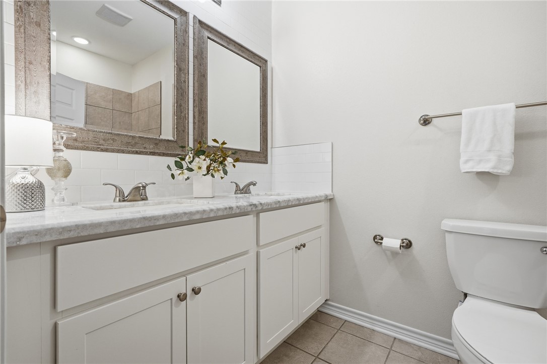 124 Lavaca Rockport, TX 78382 - Photo 24 of 39 a bathroom with a granite countertop sink a toilet and a mirror