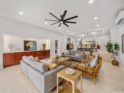 a living room with furniture kitchen view and a potted plant
