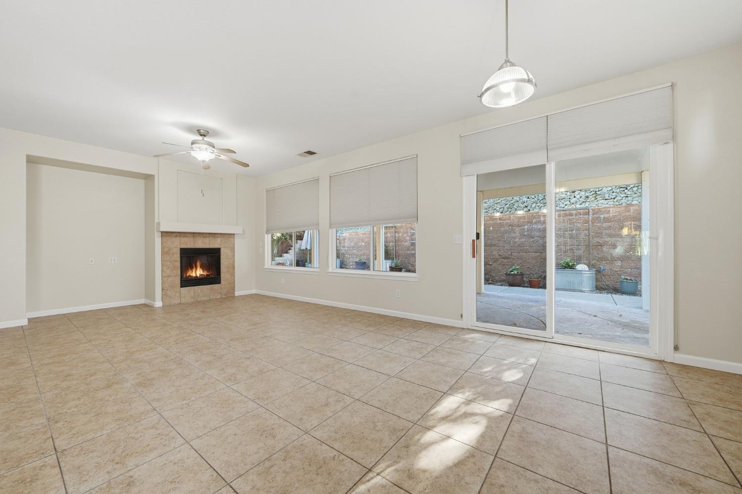 818 Alpine Street Jackson, CA 95642 - Photo 11 of 32 a view of an empty room with a fireplace and a window