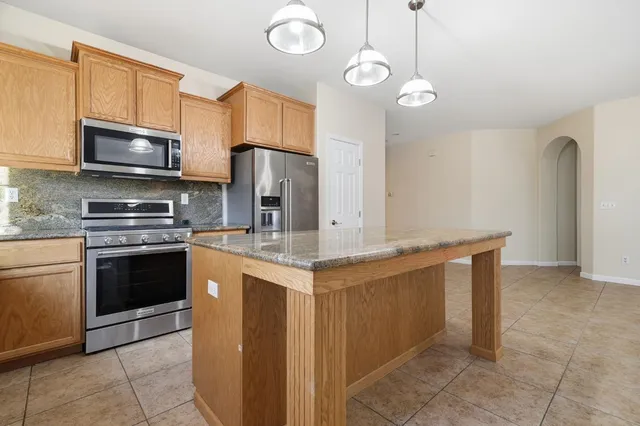 a kitchen with stainless steel appliances a stove refrigerator and microwave