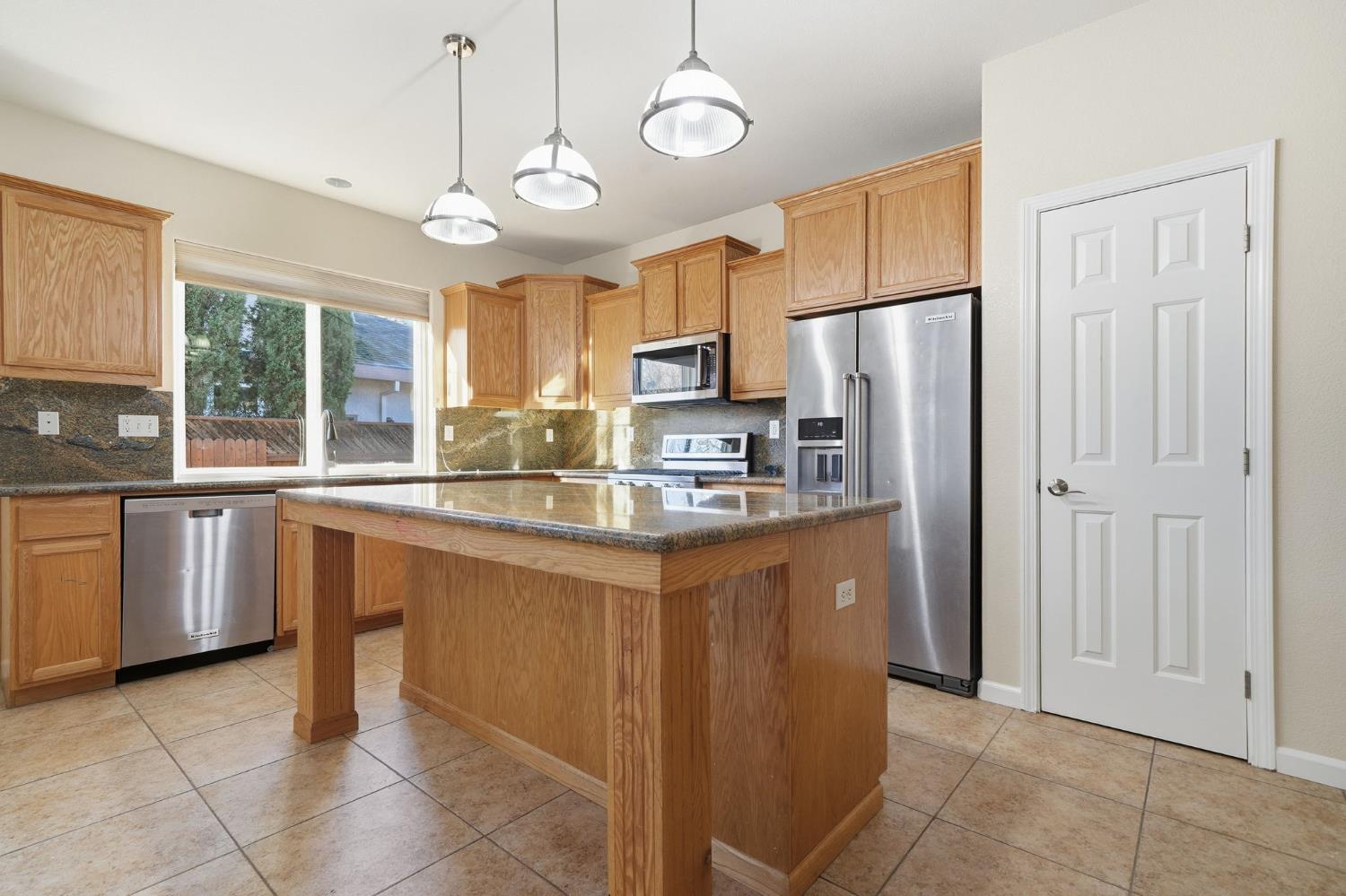 818 Alpine Street Jackson, CA 95642 - Photo 13 of 32 a kitchen with stainless steel appliances granite countertop a refrigerator a sink dishwasher a stove with wooden cabinets and floor