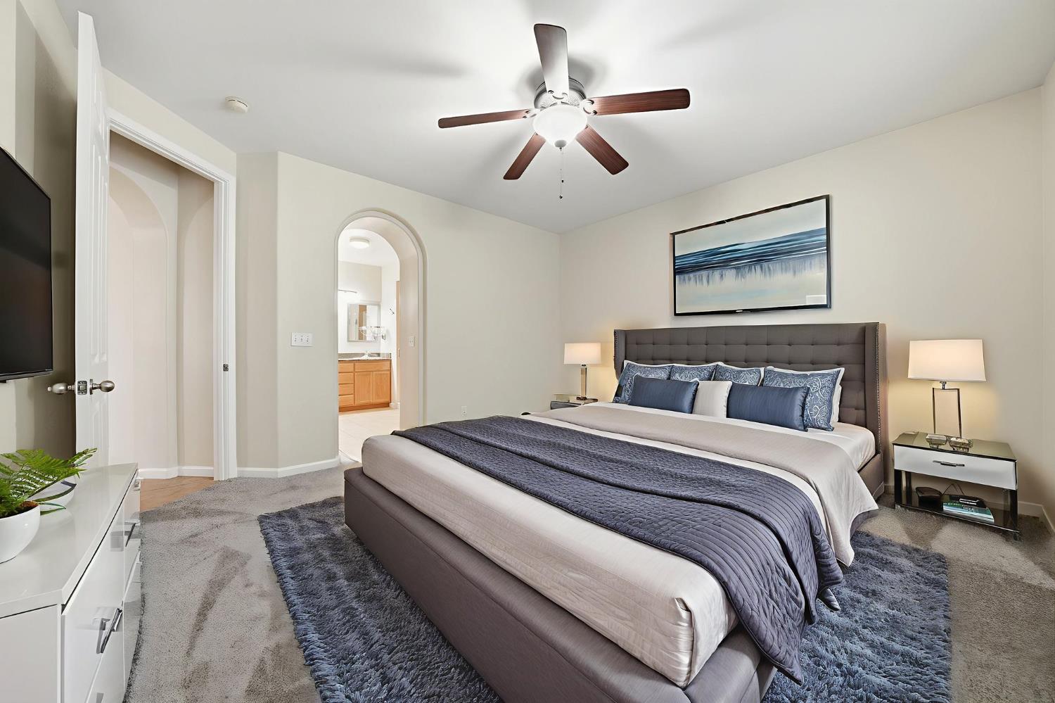 818 Alpine Street Jackson, CA 95642 - Photo 17 of 32 a bedroom with a large bed and a chandelier