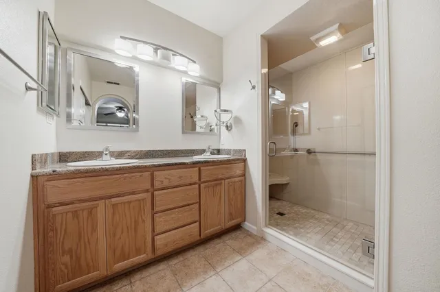 a bathroom with a granite countertop sink mirror and shower
