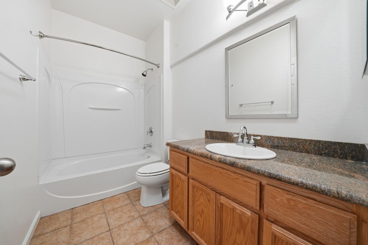 818 Alpine Street Jackson, CA 95642 - Photo 24 of 32 a bathroom with a granite countertop sink a toilet and a mirror