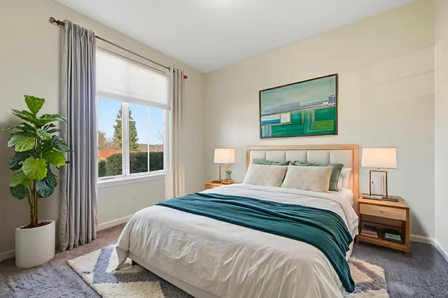 a bedroom with a bed and a potted plant