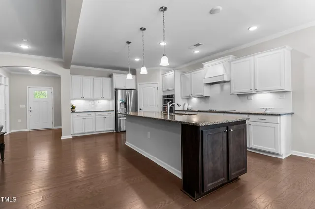 a kitchen with stainless steel appliances granite countertop a sink a stove and a refrigerator