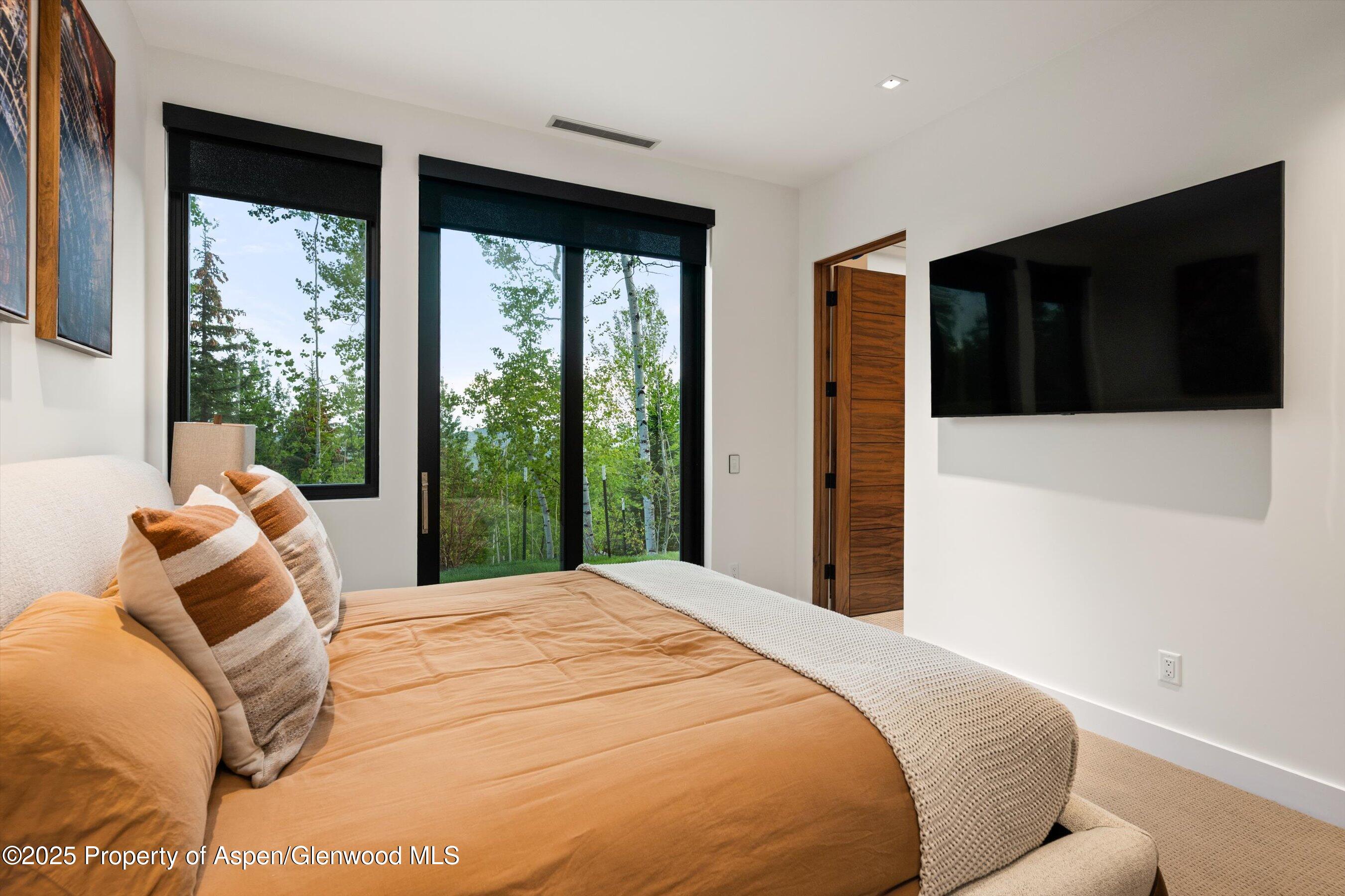 1234 Wood Road Snowmass Village, CO 81615 - Photo 53 of 66 a bedroom with a large bed and a large window